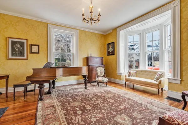 a living room with a fireplace windows and wooden floor