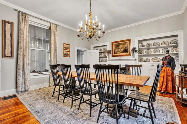 a kitchen with a stove a table and chairs in it