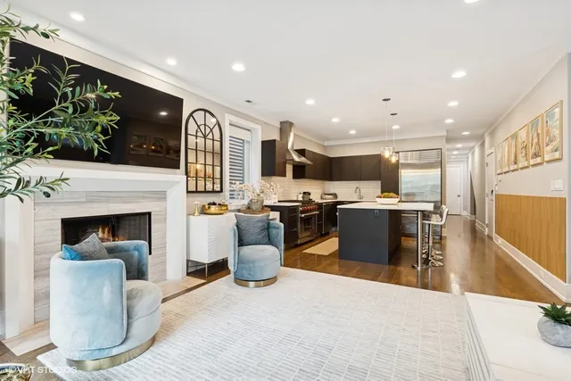 a living room with furniture a fireplace and a kitchen view