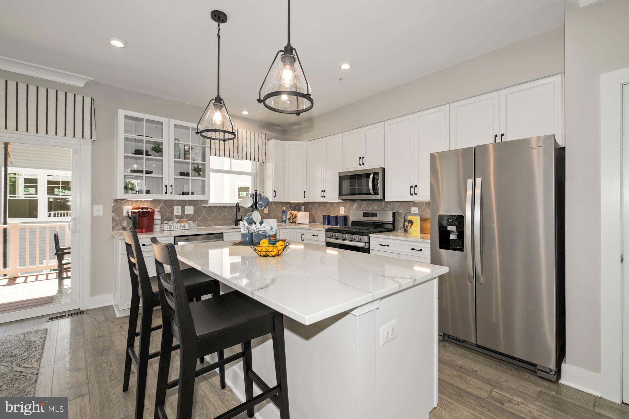 4 Riverside Wharf Cambridge, MD 21613 - Photo 10 of 28 a kitchen with stainless steel appliances a table chairs refrigerator and microwave