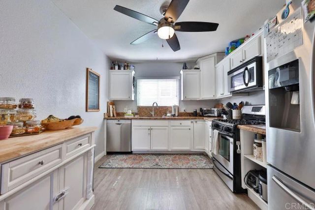 a kitchen with stainless steel appliances granite countertop a stove a sink dishwasher and a refrigerator