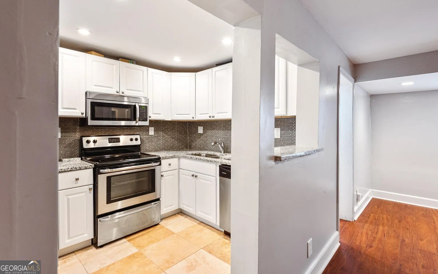 1143 United Avenue Southeast, Unit B Atlanta, GA 30316 - Photo 3 of 17 a kitchen with stainless steel appliances granite countertop a stove a microwave and a refrigerator
