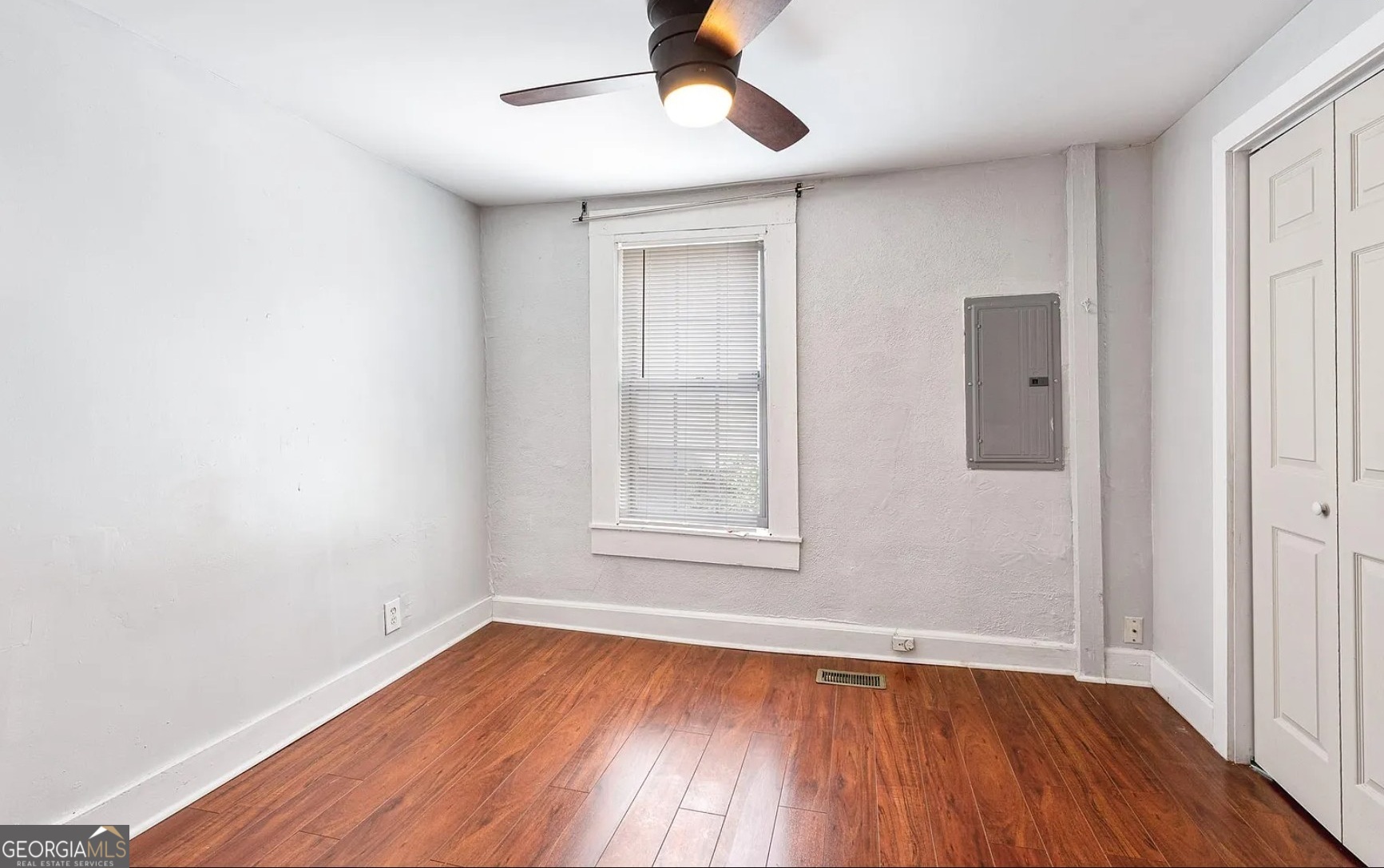 1143 United Avenue Southeast, Unit B Atlanta, GA 30316 - Photo 6 of 17 an empty room with wooden floor chandelier fan and windows