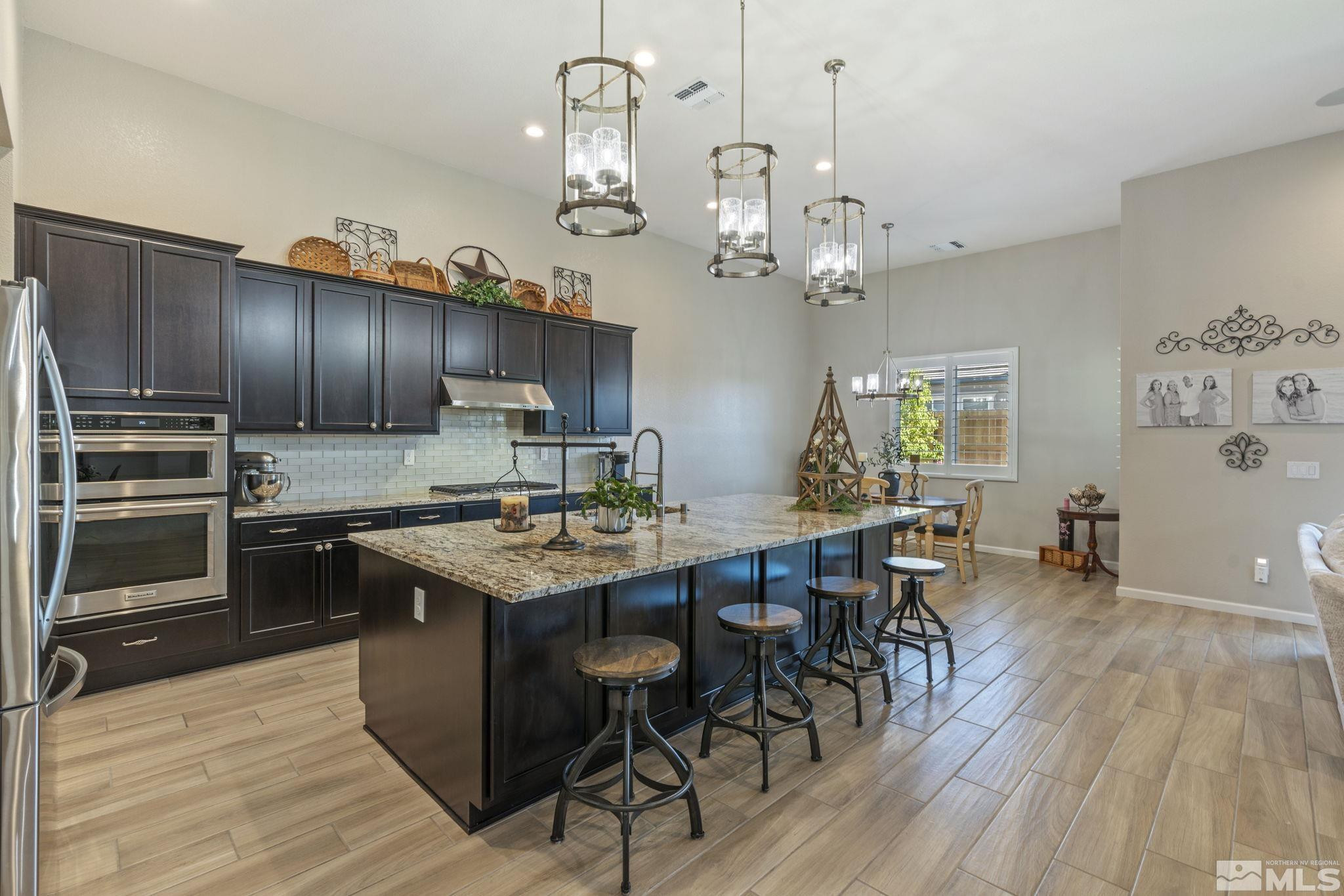 2420 Buttermere Court Reno, NV 89521 - Photo 11 of 40 a kitchen with granite countertop stainless steel appliances a table chairs refrigerator and cabinets