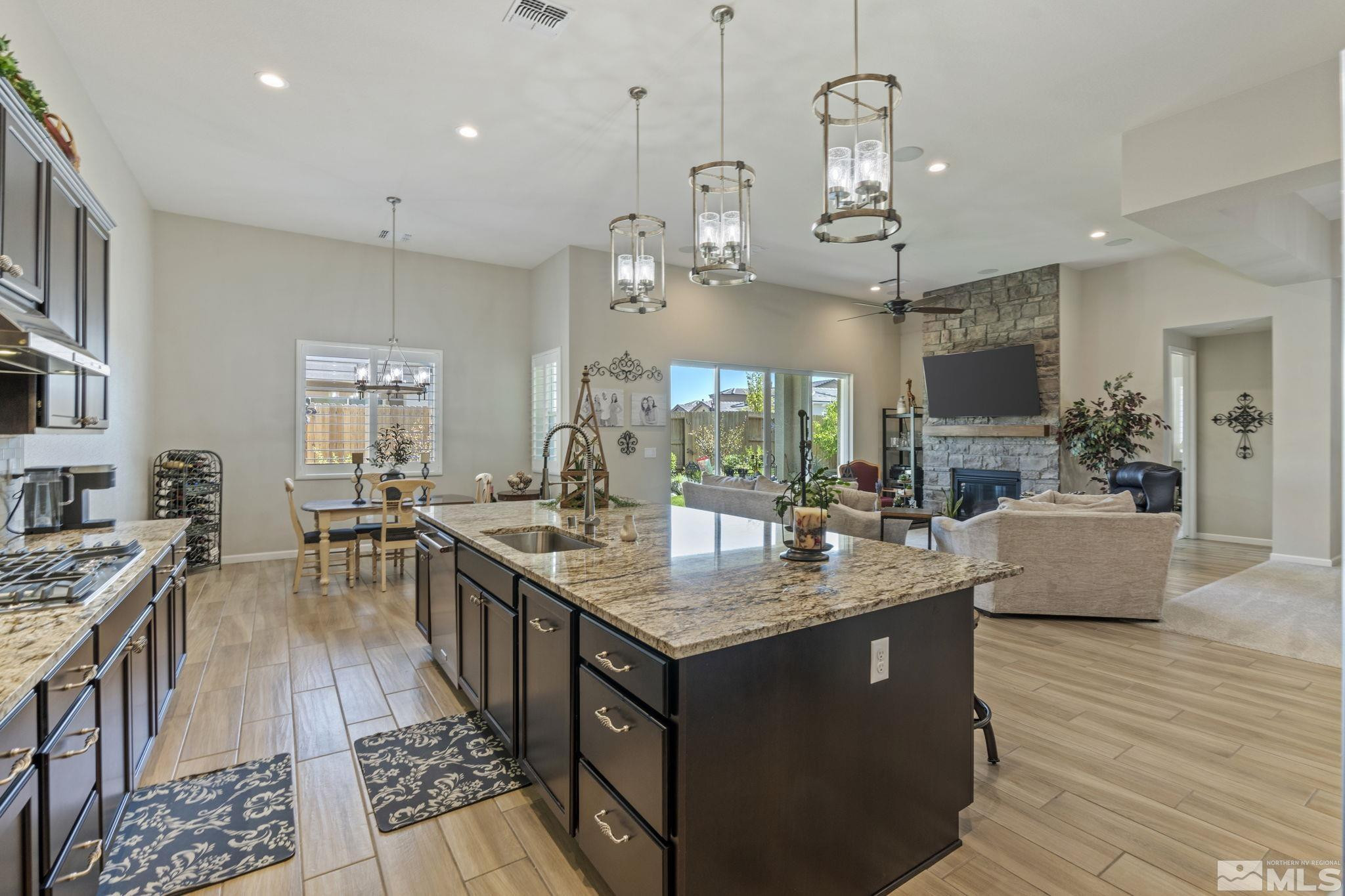 2420 Buttermere Court Reno, NV 89521 - Photo 14 of 40 a large kitchen with granite countertop a large stove a sink dishwasher a dining table and chairs with wooden floor