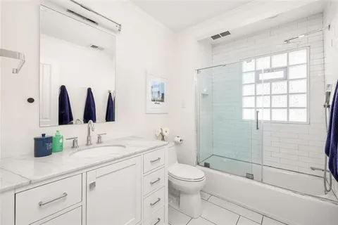 a bathroom with a double vanity sink toilet and shower