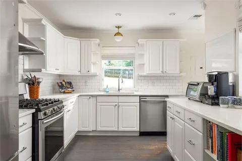 a kitchen with cabinets appliances a sink and a window
