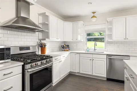 a kitchen with white cabinets and a stove top oven