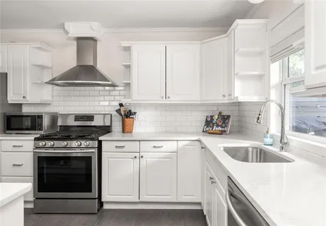 a kitchen with granite countertop a stove top oven sink and cabinets