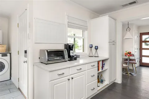 a kitchen with white cabinets and sink