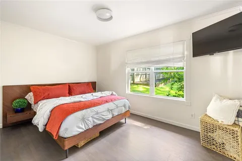 a bed sitting in a bedroom next to a window