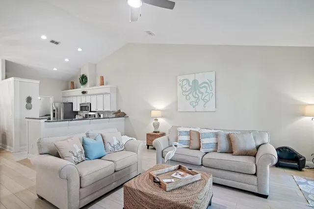 a living room with furniture and a view of kitchen