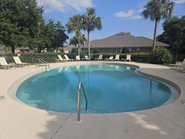a view of a swimming pool with a table and chairs under an umbrella