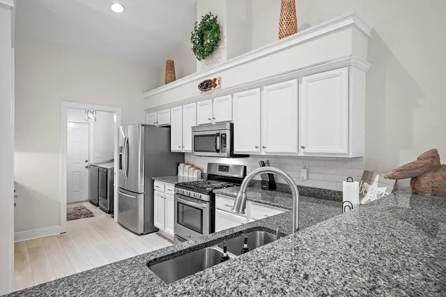 a kitchen with stainless steel appliances granite countertop a refrigerator sink and stove
