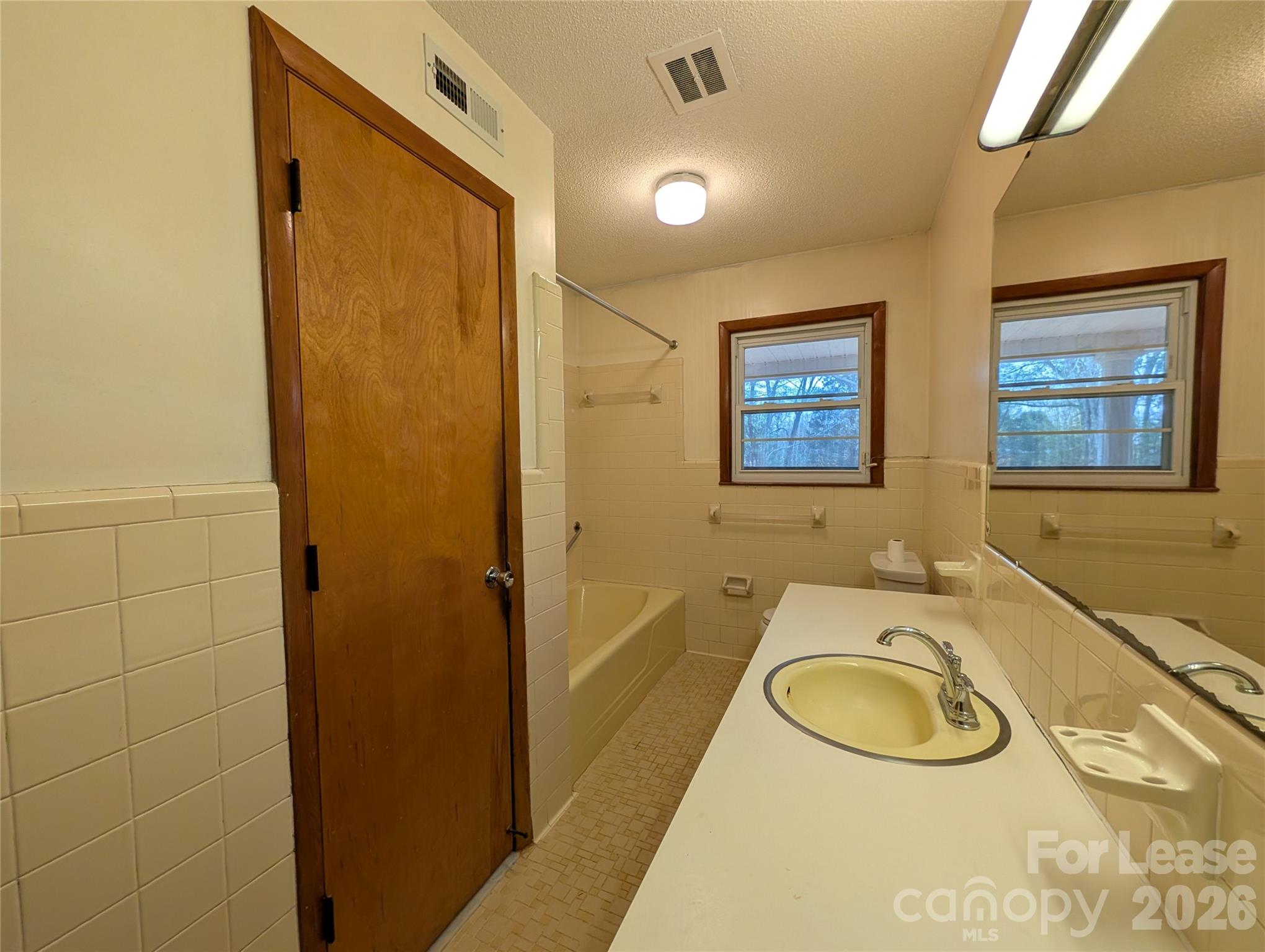805 Edgewood Road Bessemer City, NC 28016 - Photo 17 of 19 a bathroom with a granite countertop sink a large mirror a shower and a bathtub