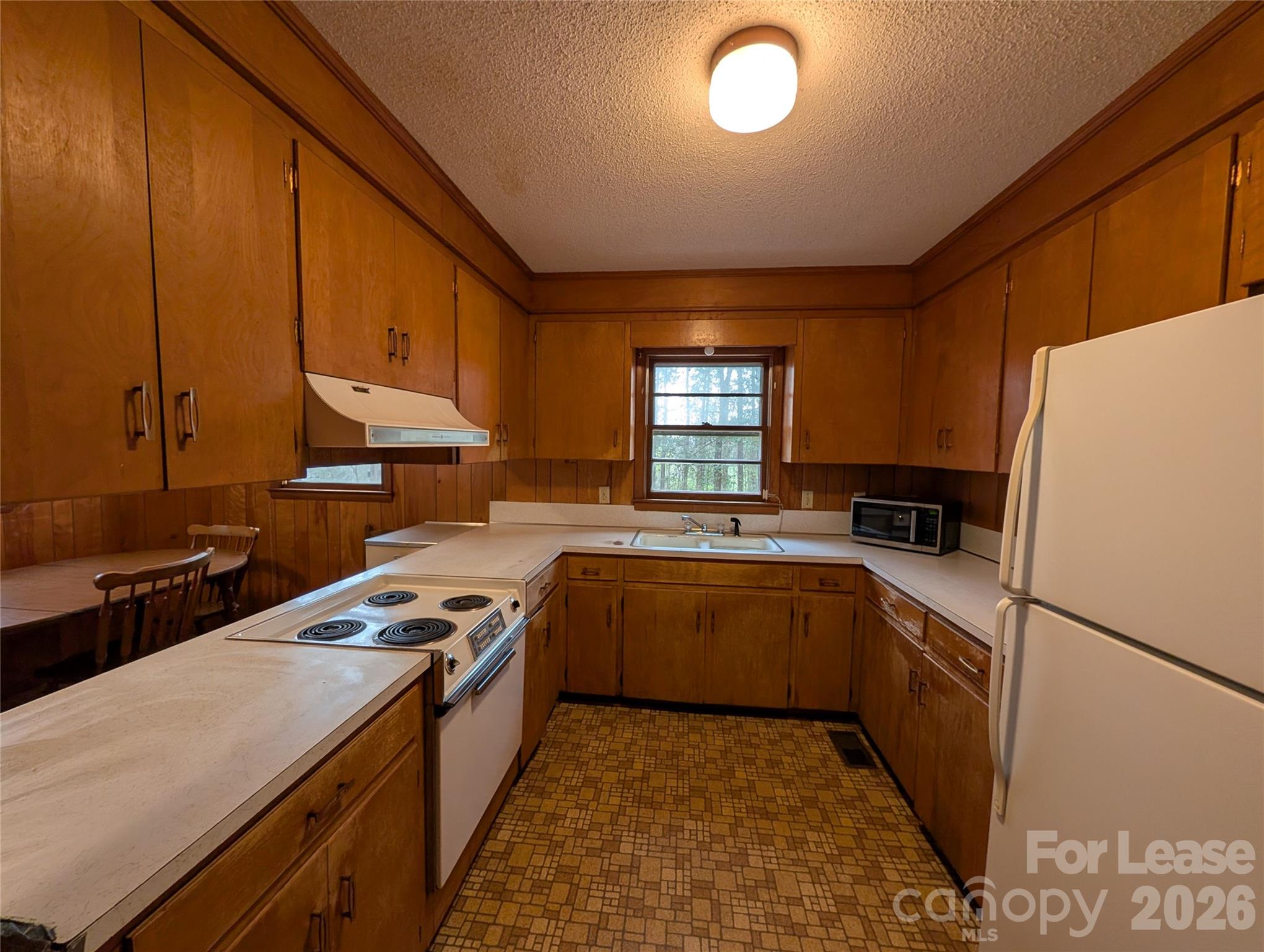 805 Edgewood Road Bessemer City, NC 28016 - Photo 5 of 19 a kitchen with a sink a stove top oven a refrigerator and cabinets