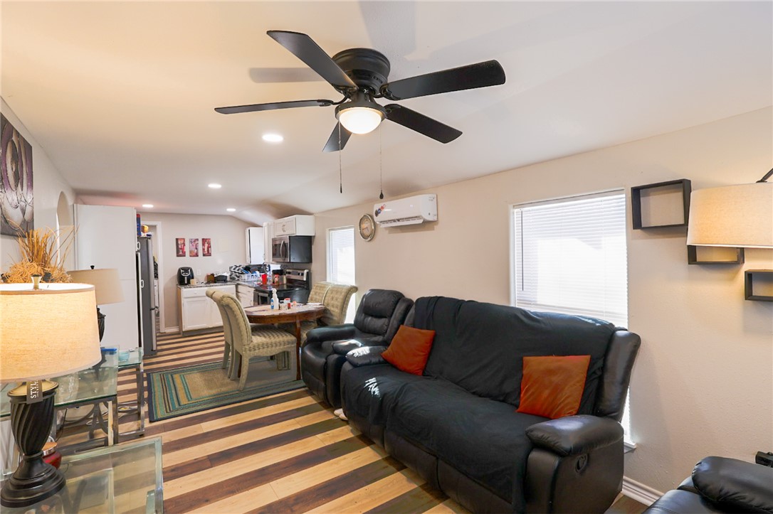 a living room with furniture kitchen view and a window