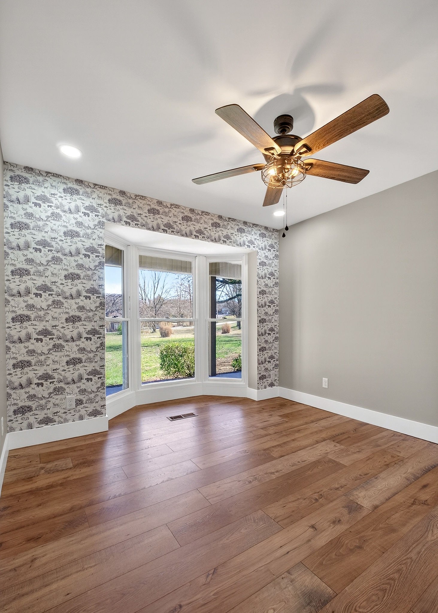 3857 Baxter Road Baxter, TN 38544 - Photo 19 of 52 a view of an empty room with wooden floor and a ceiling fan