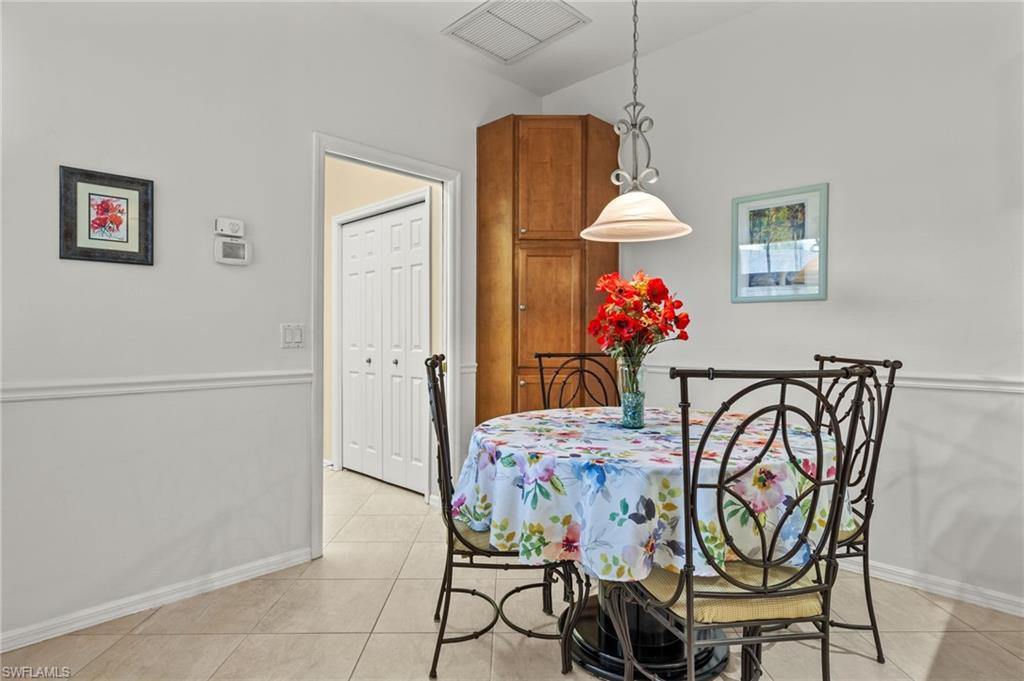 23164 Grassy Pine Drive Estero, FL 33928 - Photo 13 of 43 a dining room table chair and chandelier