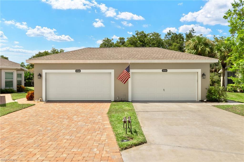 23164 Grassy Pine Drive Estero, FL 33928 - Photo 4 of 43 a front view of a house with a yard and garage