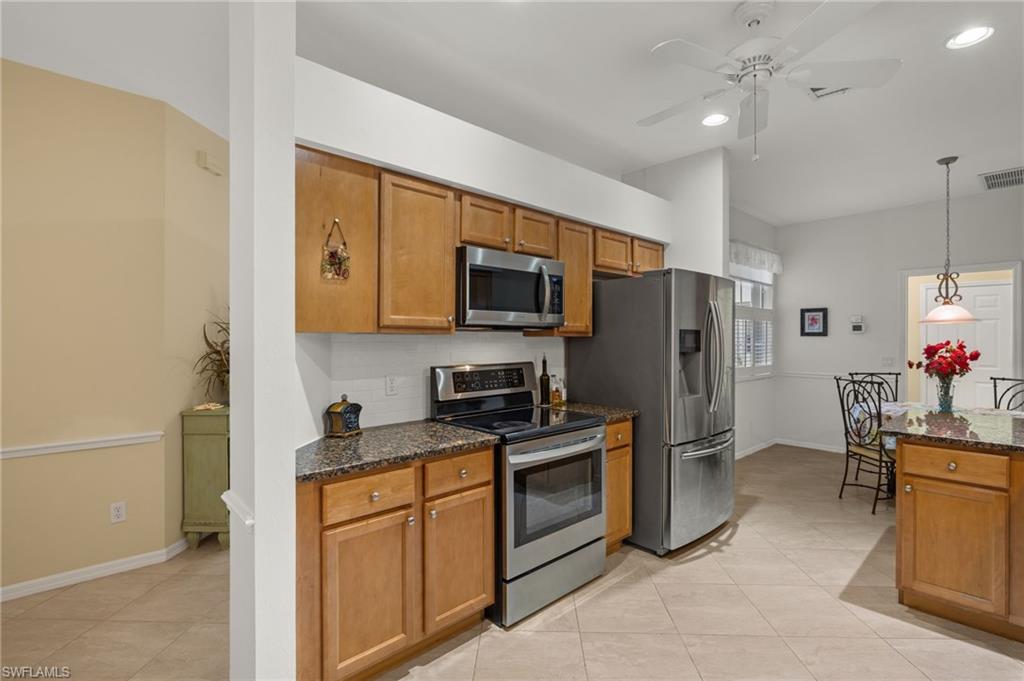 23164 Grassy Pine Drive Estero, FL 33928 - Photo 10 of 43 a kitchen with stainless steel appliances granite countertop a refrigerator stove and sink