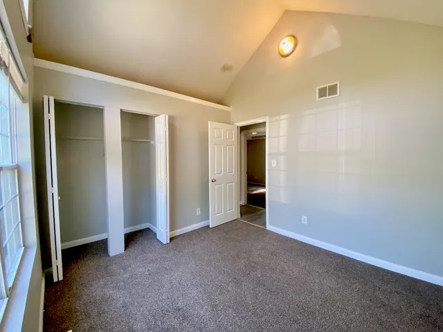 an empty room with closet and mirror