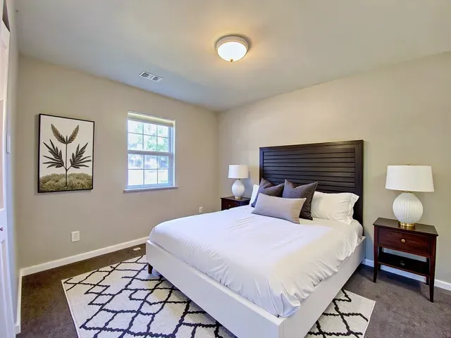 a bedroom with a bed and a lamp