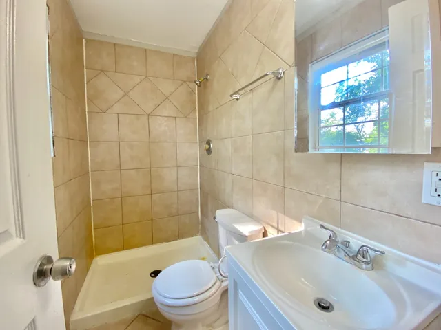 a bathroom with a sink a toilet and shower