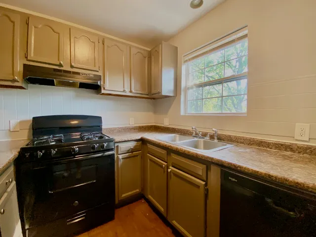 a kitchen with stainless steel appliances granite countertop a stove a sink and a microwave