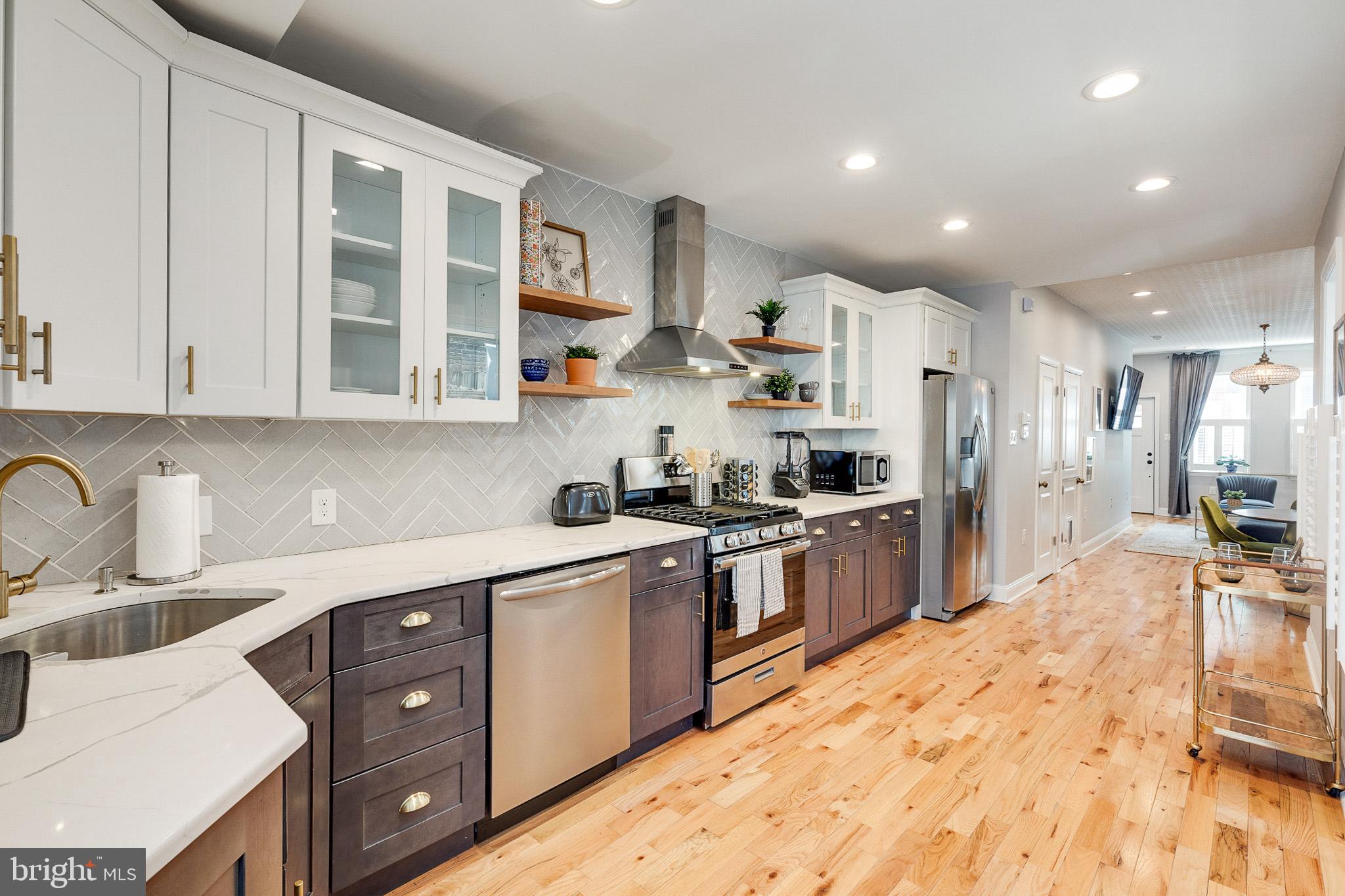 1935 Cambridge Street Philadelphia, PA 19130 - Photo 12 of 54 a kitchen with stainless steel appliances kitchen island granite countertop a sink and cabinets
