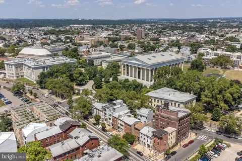 a couple of cars is parked in front of a building