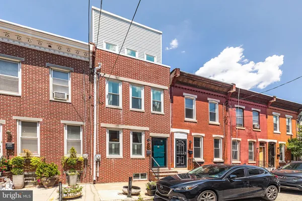 a view of a blue house with iron fence