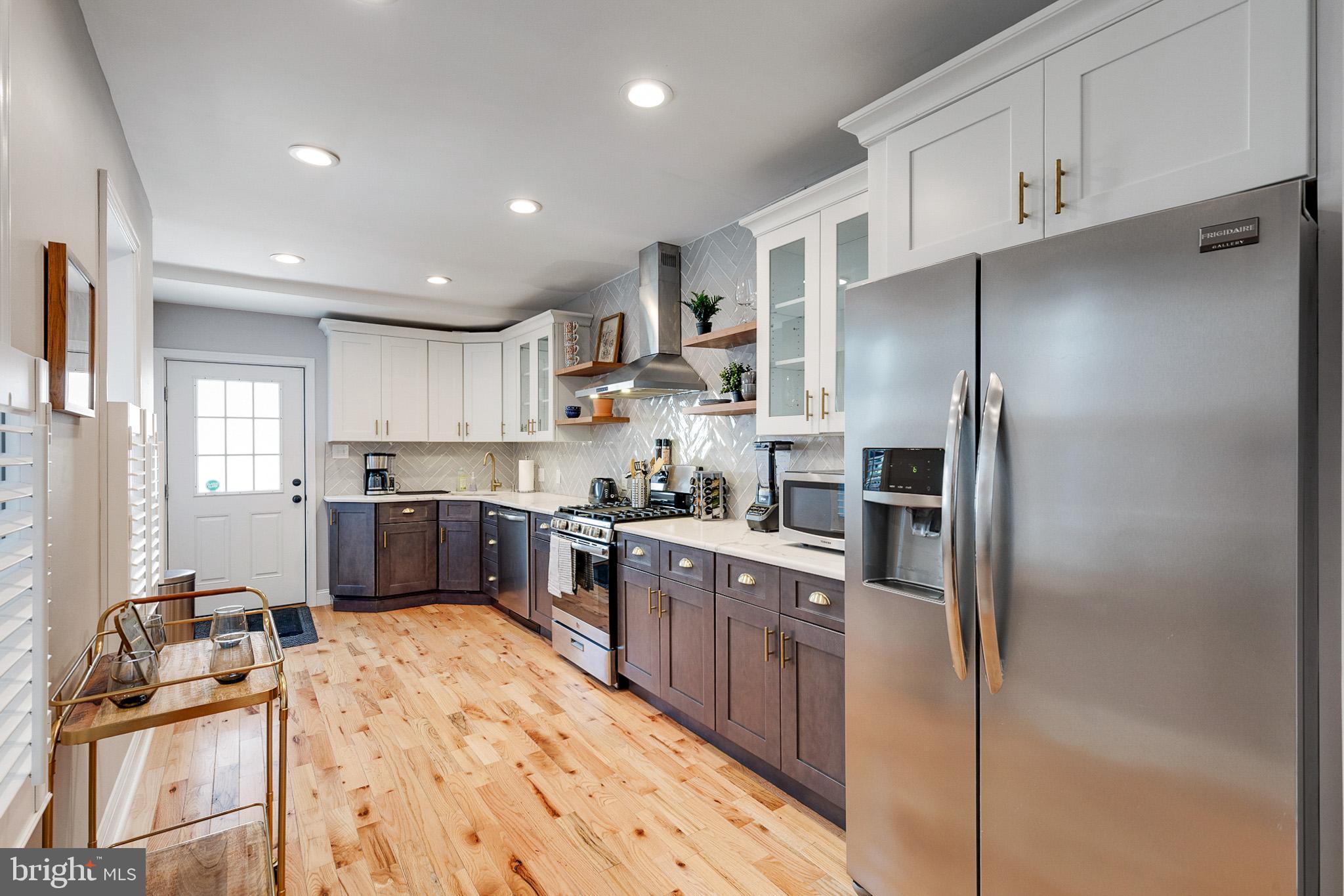 1935 Cambridge Street Philadelphia, PA 19130 - Photo 10 of 54 a large kitchen with stainless steel appliances kitchen island granite countertop a refrigerator and cabinets