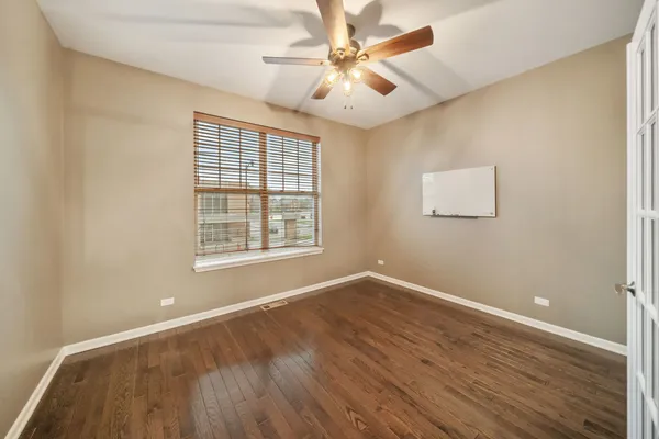 a view of an empty room with window and wooden floor