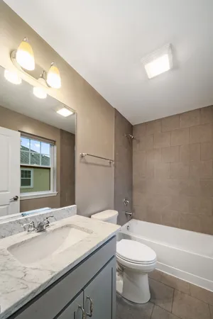a bathroom with a granite countertop sink a toilet and bathtub