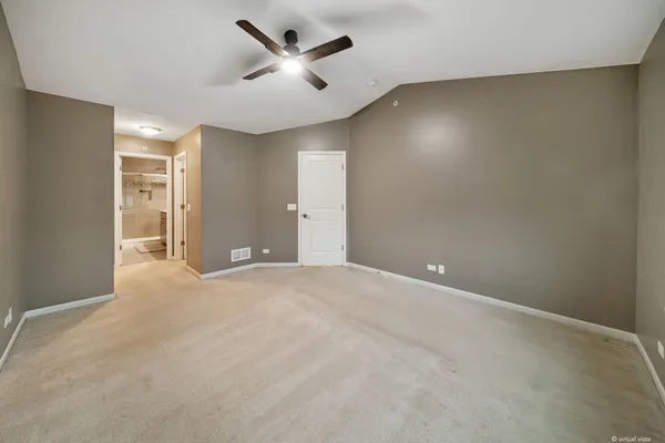 an empty room with a ceiling fan and a window