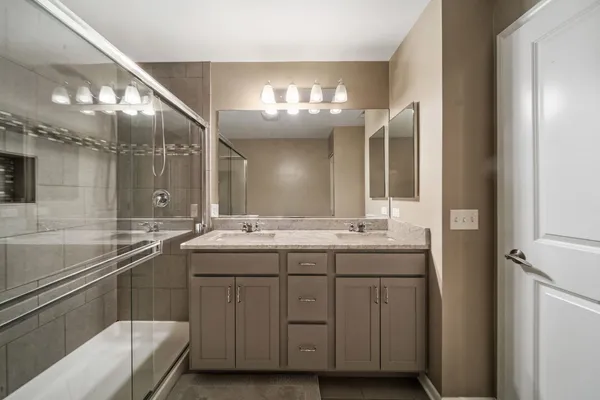 a bathroom with a sink double vanity granite and a bathtub