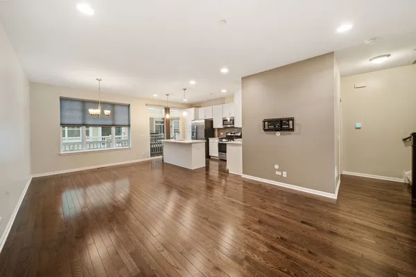 a view of kitchen with refrigerator and wooden floor