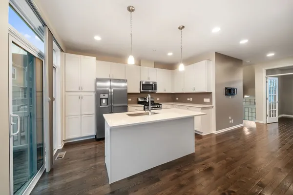 a view of kitchen with granite countertop a sink refrigerator and a stove