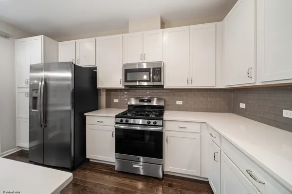 a kitchen with cabinets stainless steel appliances and wooden floor