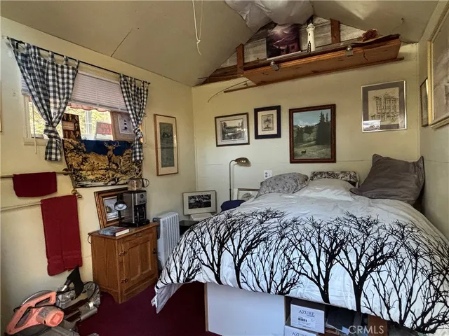 a bedroom with a bed and painting on the wall