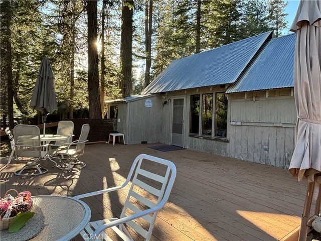 a backyard of a house with barbeque oven tree and outdoor seating