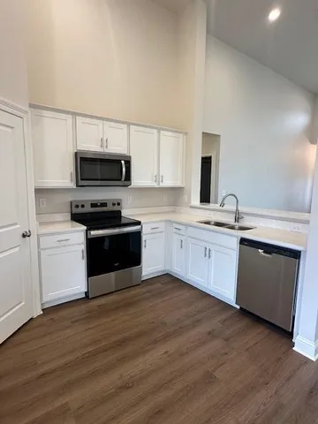 a kitchen with a sink cabinets and wooden floor