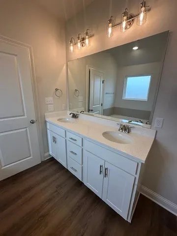 a spacious bathroom with a double vanity sink and mirror
