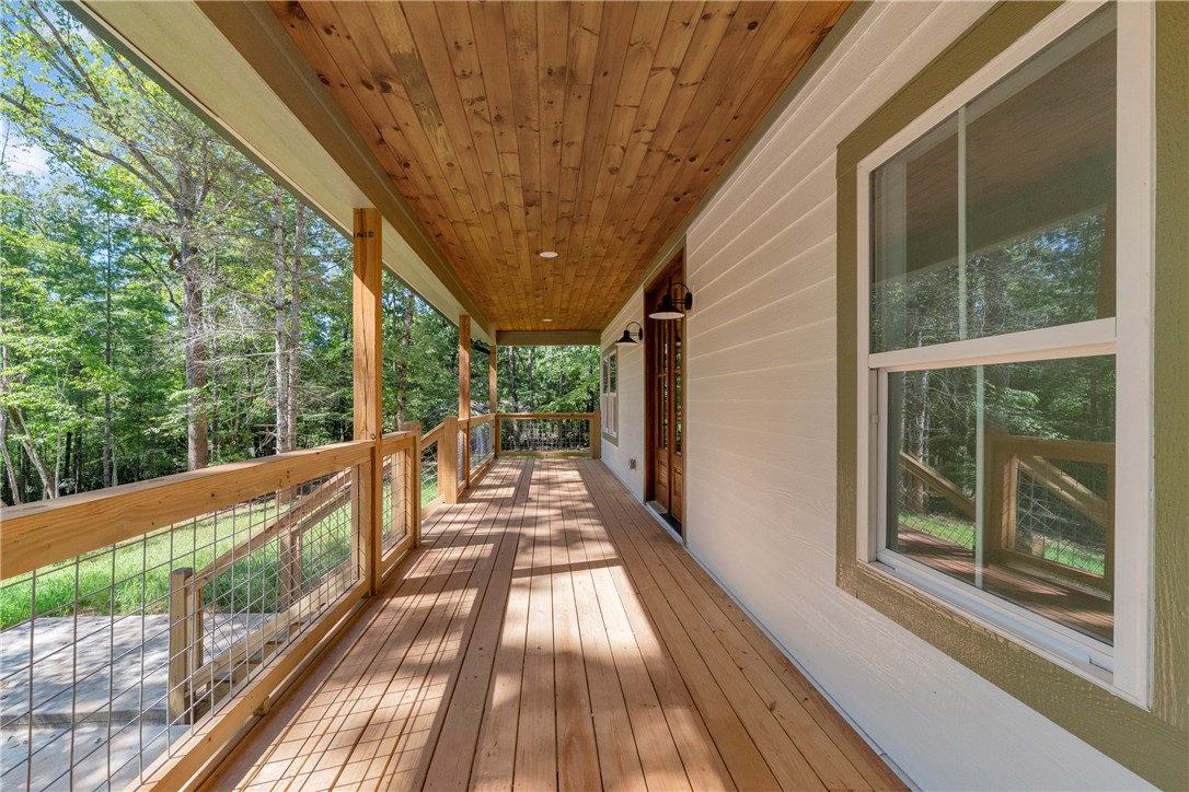 659 White Oak Farms Road Tamassee, SC 29686 - Photo 8 of 50 Rich wood planking lines the ceiling of this long covered porch overlooking the trees.