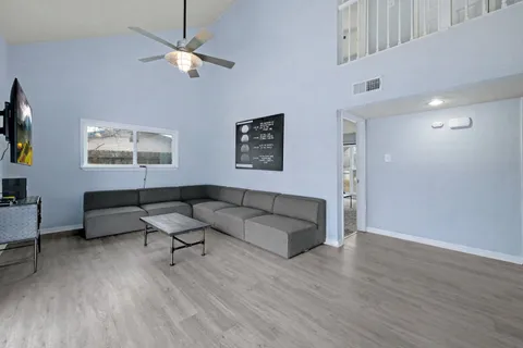 a living room with furniture kitchen view and a chandelier