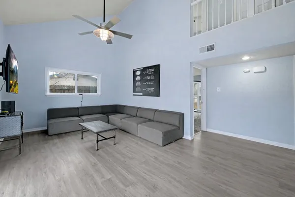 a living room with furniture kitchen view and a chandelier