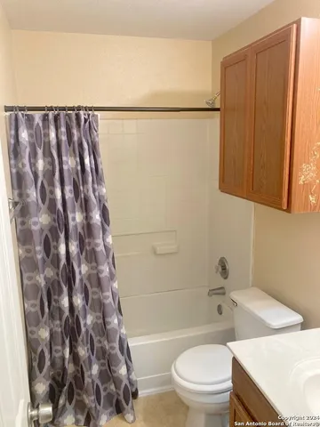 a bathroom with a toilet and a shower curtain