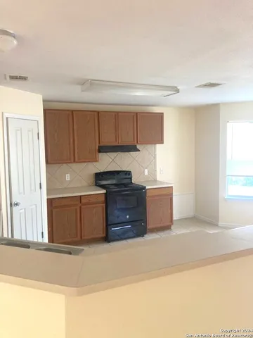 a kitchen with granite countertop a stove a sink and a granite counter tops
