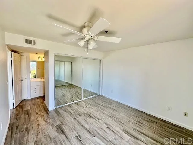 a view of a room with wooden floor and ceiling fan